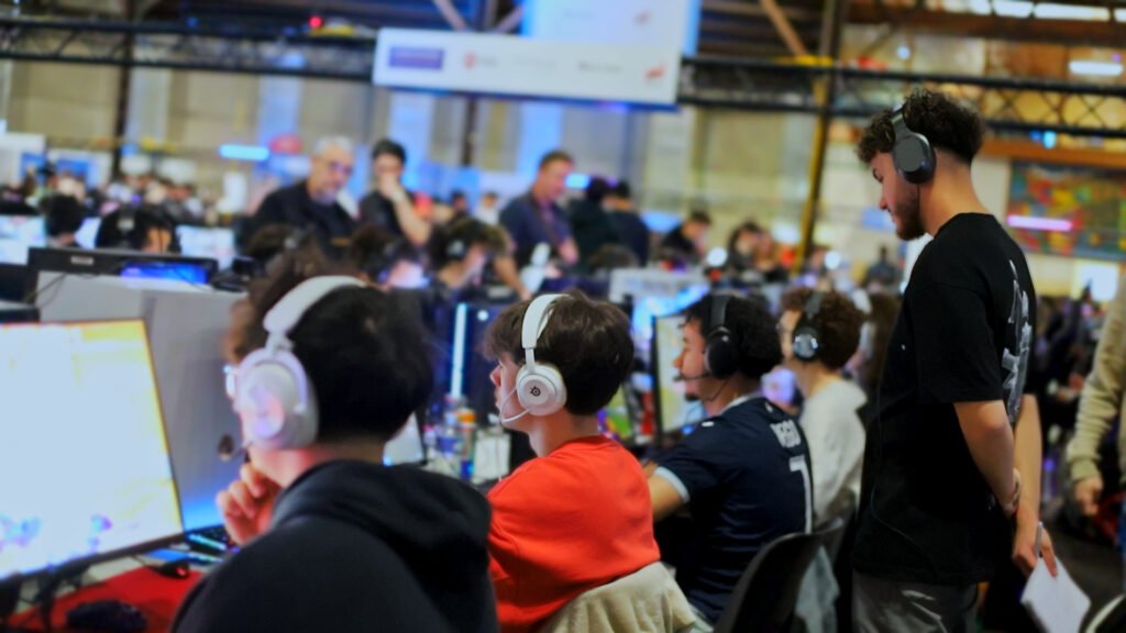 Les joueurs de Level One installés devant leurs écrans en LAN, accompagnés au bord des postes.